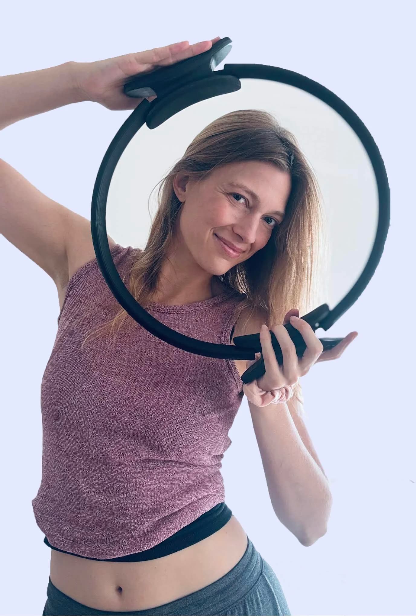 Ginny, founder and instructor of Embodied Pilates, smiling through a pilates ring